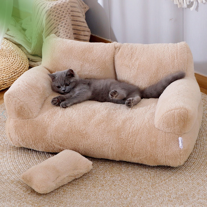 Cat lying on plush pet sofa with pillow
