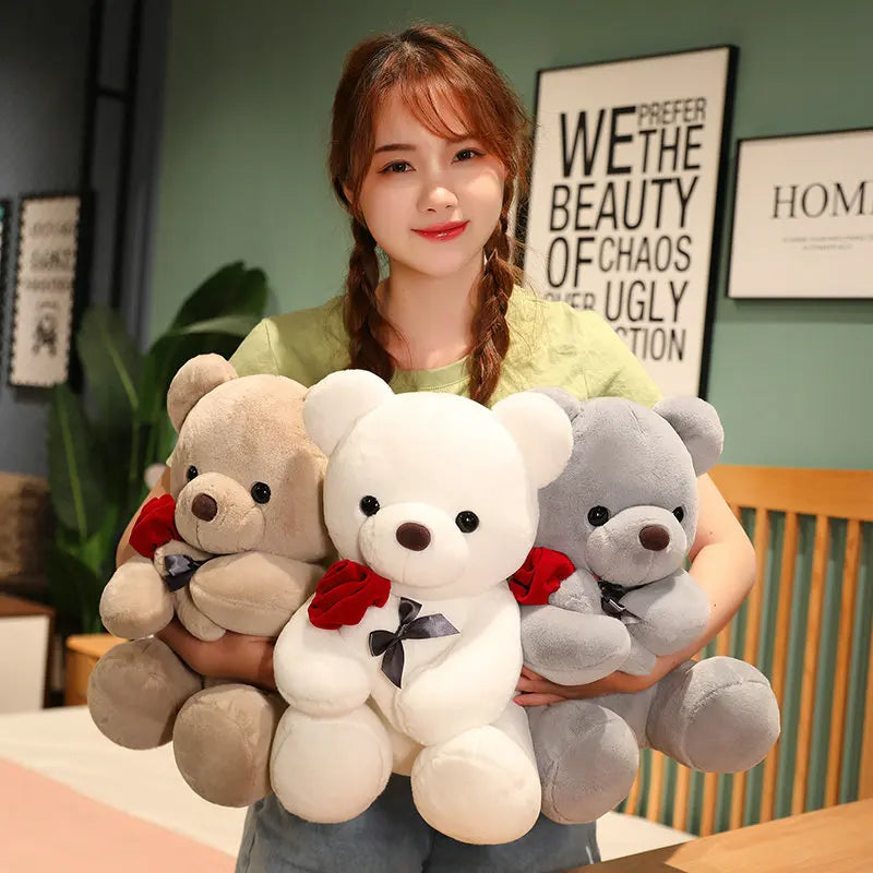 Brown teddy bear holding a red rose