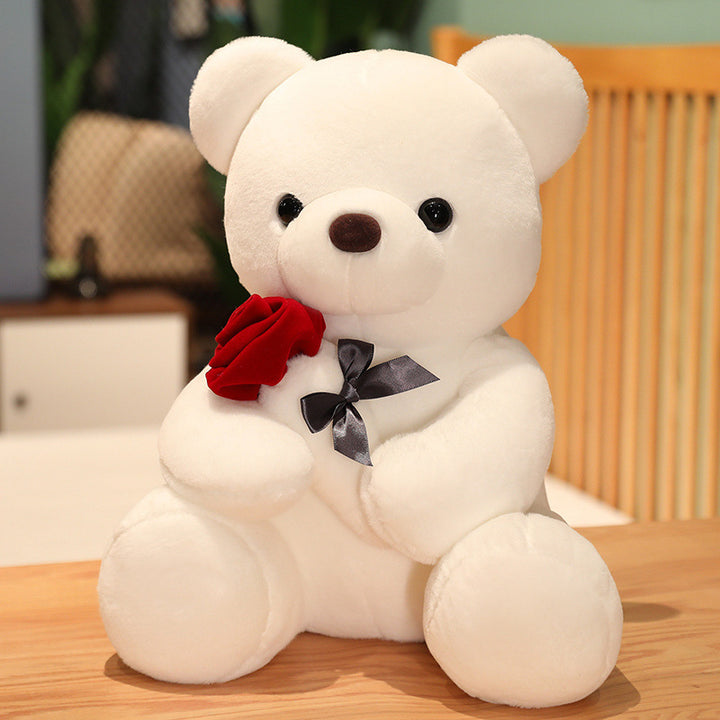 Brown teddy bear holding a red rose