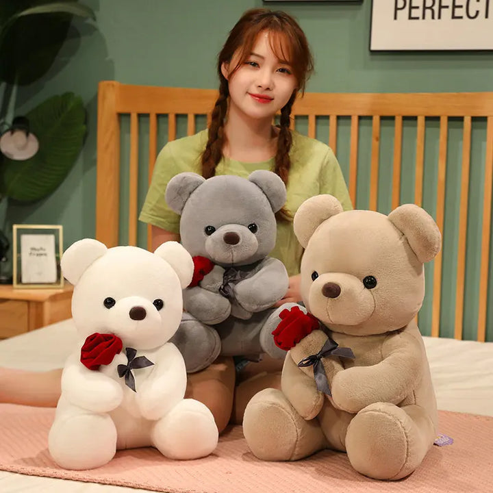 Brown teddy bear holding a red rose